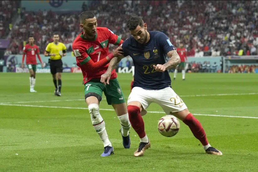 Theo Hernandez dari Prancis, kanan, menantang bola dengan Hakim Ziyech dari Maroko selama pertandingan sepak bola semifinal Piala Dunia antara Prancis dan Maroko di Stadion Al Bayt di Al Khor, Qatar, Rabu, 14 Desember 2022. (Francisco Seco)