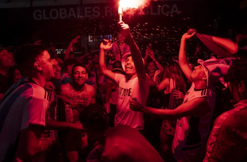 Penggemar sepak bola Argentina menyalakan suar merayakan kemenangan tim mereka di Piala Dunia atas Prancis di Buenos Aires, Argentina, Minggu, 18 Desember 2022. (Rodrigo Abd)